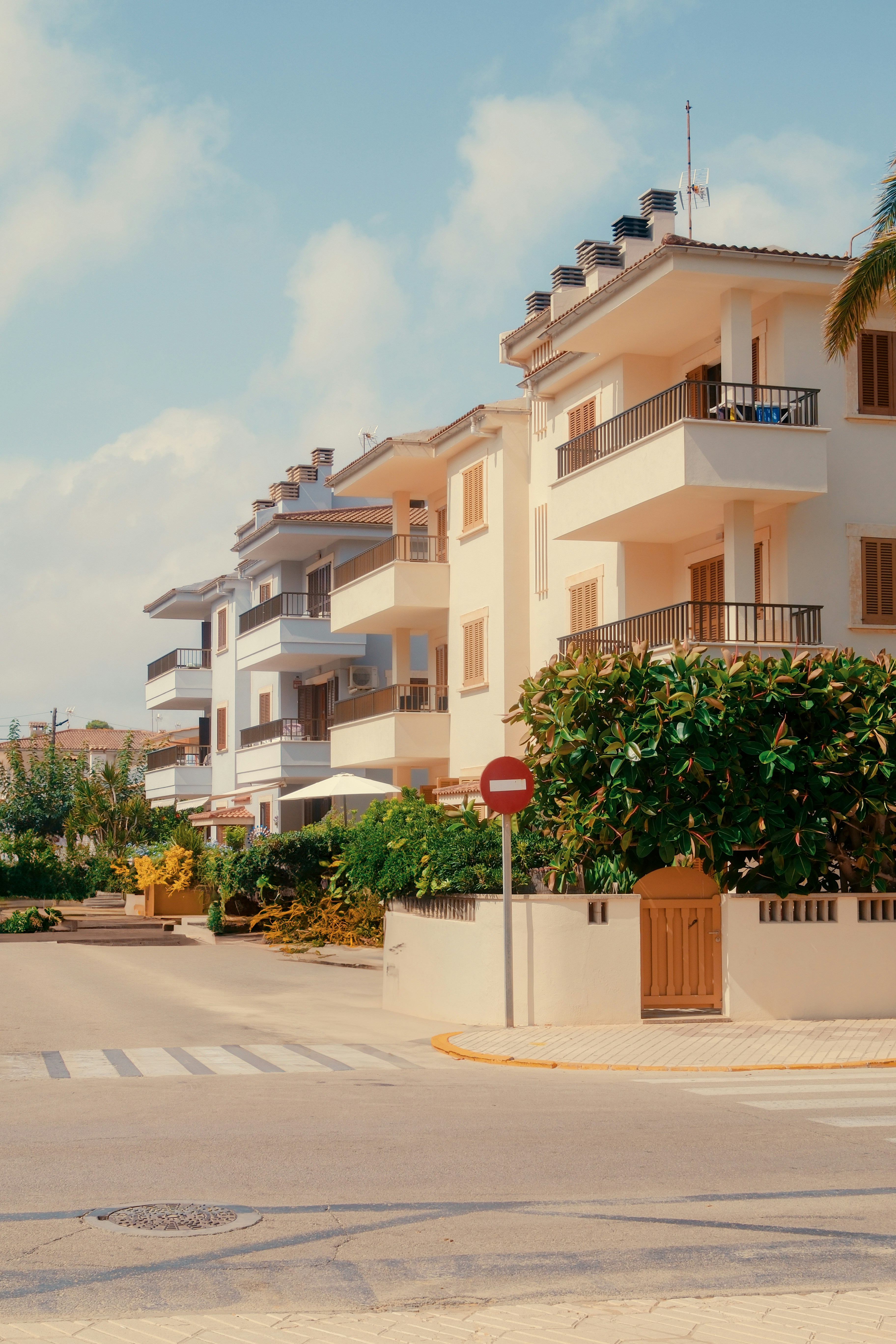 A row of white apartment buildings next to a street